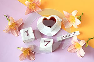Calendar for August 17 :the name of the month of August in English, cubes with the number 17, a cup of tea in the shape of a heart