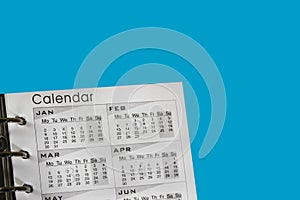 Calendar on a blue background for planning. Close-up on top of a white calendar with a monthly schedule to make an appointment or