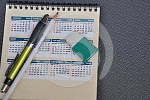 Calendar. Brazilian calendar printed with the months of the year and aluminum pen with pencil and eraser in zoom view with copy sp