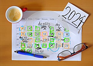 Calendar with business appointments for the new year 2024,pen,coffee cup and spectacles, monthly schedule with days off for better