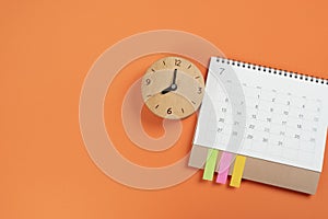 calendar and clock on the colorful table background, planning for business meeting or travel planning concept