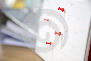Calendar, Close-up red pin on blank desk calendar with paper stack and office equipment concept of event planner or personal