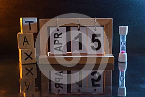 Calendar with date 15th April and cubes with word `tax