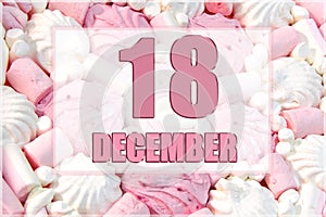 calendar date on the background of white and pink marshmallows. December 18 is the eighteenth day of the month