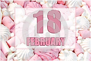 calendar date on the background of white and pink marshmallows. February 18 is the eighteenth day of the month