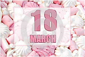 calendar date on the background of white and pink marshmallows. March 18 is the eighteenth day of the month