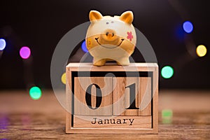 Calendar date of Financial Year start, 1st january with piggy bank on dark background