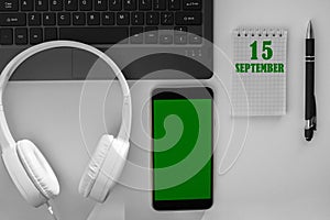 calendar date on a light background of a desktop and a phone with a green screen. September 15 is the fifteenth day of the month