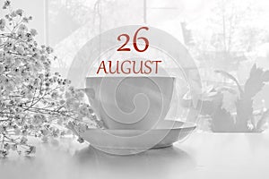 Calendar date on light background with porcelain white tea pair and white gypsophila with copy space. August 26 photo