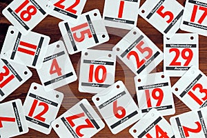 Calendar dates spread out on a wooden desk.