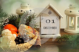 Calendar for December 1: decorative house with the name of the month December, number 01, holiday gingerbread, tangerines, cones