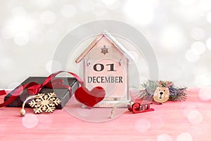 Calendar for December 1: decorative house with the name of the month in English, number 01, gift wrapped, tied with a red ribbon,
