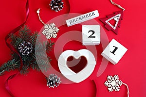 Calendar for December 21: the name of the month in English, cubes with the number 21, a cup of tea in the shape of a heart, a fir