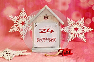 Calendar for December 24: a decorative house with the name of the month of December, the numbers 24 on it, decorative snowflakes,