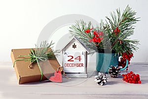 Calendar for December 24: a decorative house with the numbers 24, the name of the month December in English, a gift, a red heart,