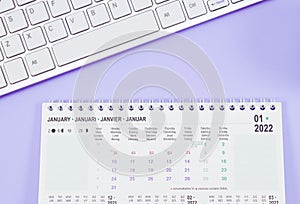 Calendar for January 2022 with the keyboard lie on a light lilac background.