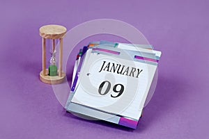 Calendar for January 9: loose-leaf calendar with the name of the month in English, numbers 09, hourglass on a pastel background