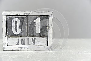 Calendar for July 01, made of wooden cubes, on gray background.With an empty space for your text.