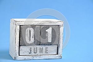 Calendar for June 01 made wooden cubes standing blue background. With empty space for text.