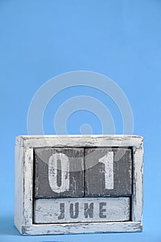 Calendar for June 01 made wooden cubes standing blue background. With empty space for text.