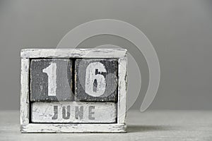 Calendar for June 16, made wooden cubes, on gray background.With an empty space for your text.