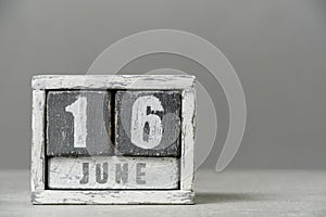 Calendar for June 16, made wooden cubes, on gray background.With an empty space for your text. photo