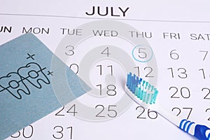 Calendar with a marked date and toothbrush.