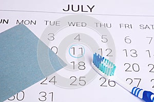 Calendar with a marked date and toothbrush.