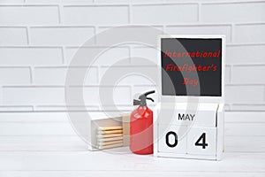 Calendar with May 4 day and a fire extinguisher on a light background.