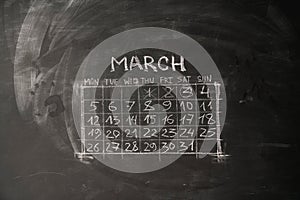 calendar month March is painted on a chalkboard.