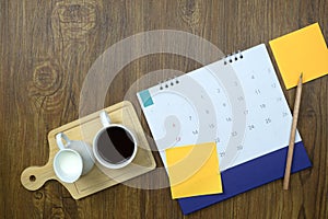 Calendar with note paper and coffee on wooden texture background. Plan notepad list concept. Notebook for Planner plan timetable