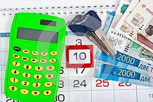 Calendar with the number 10, calendar, calculator, bunch of keys and a pack of Russ rubles photo
