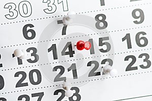 Calendar with numbers marked with white and red push pins. The number of February 14. Background for Valentine`s Day