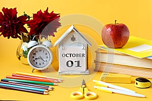 Calendar for October 1 : a decorative house with the name of the month in English and the numbers 01, a bouquet of dahlias, books
