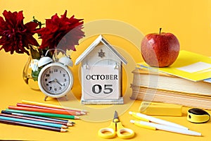 Calendar for October 5 : decorative house with the name of the month in English and the numbers 05, a bouquet of dahlias, books,