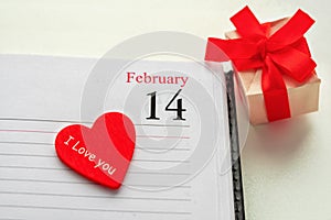 Calendar page with the red heart and the text I love you and a gift box on February 14 of Saint Valentines day