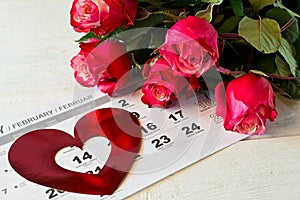 Calendar page with the red hearts and bouquet of red roses on Valentines day.