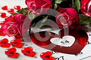 Calendar page with the red hearts and bouquet of red roses on Valentines day.