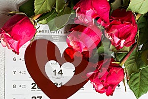 Calendar page with the red hearts and bouquet of red roses on Valentines day.