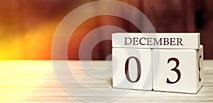 Calendar reminder event concept. Wooden cubes with numbers and month on December 3 with sunlight