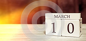 Calendar reminder event concept. Wooden cubes with numbers and month on March 10 with sunlight