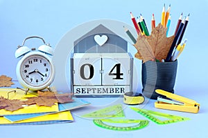 Calendar for September 4 : the name of the month of September in English, cubes with the numbers 04, clocks, school supplies,