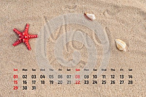 Calendar with starfish and seashells on sand beach. May 2016