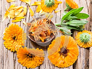 Calendula or marigold flowers on the old wooden table.