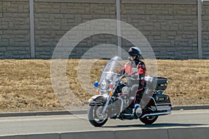 A police officer riding a motorcycle during early spring