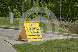 Side view to a Voting Place Elections Alberta sign, yellow double sided floor stand