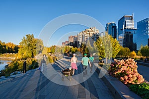 People walking on Bow River pathway in the Autumn season