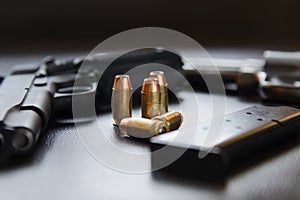 .45 Caliber hollow point bullets near handgun and magazine
