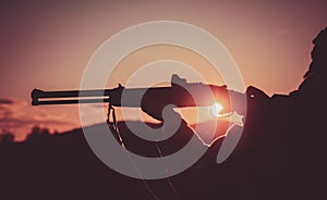 Calibers of hunting rifles. Rifle Hunter Silhouetted in Beautiful Sunset. Silhouette of the hunter. Pulled the trigger