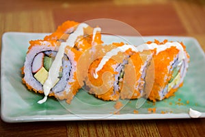 California Maki Sushi with Masago - Roll made of Crab Meat, Avocado, Cucumber inside. Masago (smelt roe) outside